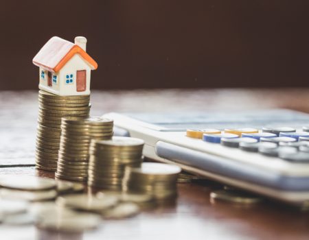 House model on top of stack of money as growth of mortgage credit, Concept of property management. Invesment and Risk Management.